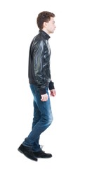 Fototapeta premium Back view of going handsome man in jacket. walking young guy