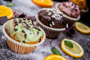 Cupcakes with fruit and powdered sugar on a dark background. Top view. Close-up