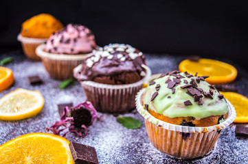 Cupcakes with fruit and powdered sugar on a dark background. Top view. Close-up