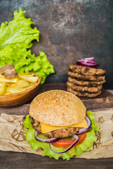 Great Hamburger and french fries on a wooden table in rustic style