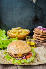 Great Hamburger and french fries on a wooden table in rustic style. Close-up