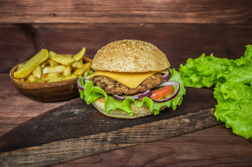 Great Hamburger and french fries on a wooden table in rustic style. Close-up