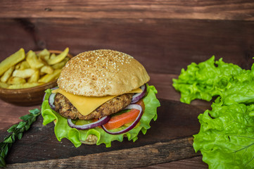 Great Hamburger and french fries on a wooden table in rustic style. Close-up