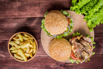 Bacon burger and French fries with beef patty on wooden table. Top view. Close-up