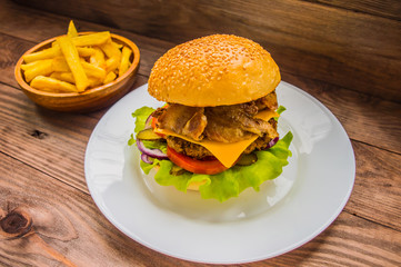 Great Hamburger and french fries on a wooden table in rustic style