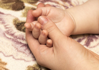 hand the baby in the hand of mother