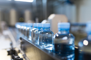 Water factory - Close up shot of water bottling line for processing and bottling pure mineral carbonated water into bottles. 