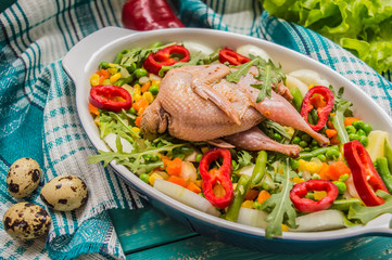Marinated quail with vegetables for subsequent cooking in the oven. At the turquoise wooden background. Top view. Close-up