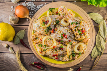 Marinated chicken in soy sauce, greens, red pepper and other spices. Derevesky background. Top view. Close-up