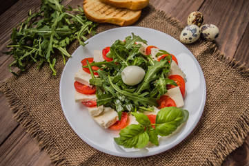 Arugula Salad - Caprese . Wooden background. Top view. Close-up