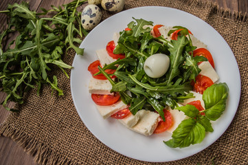 Arugula Salad - Caprese . Wooden background. Top view. Close-up