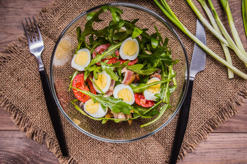 Salad with bacon and arugula. Wooden rustic background. top view