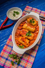 Dinner with cabbage rolls in tomato sauce decorated  parsley. Wooden blue rustic background. Top view. Close-up