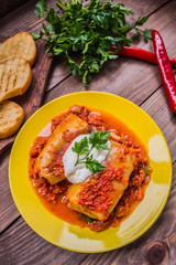 Dinner with cabbage rolls in tomato sauce decorated  parsley. Wooden rustic background. Top view. Close-up