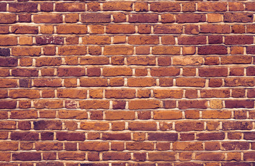 dark red brick wall - different sized and colored bricks with gray seams with a dark vintage looking color tone