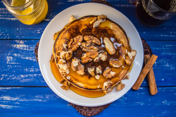 Pancakes with walnuts and maple syrup for breakfast. Close-up