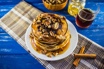 Pancakes with walnuts and maple syrup for breakfast. Close-up
