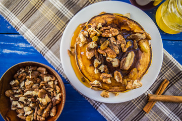 Pancakes with walnuts and maple syrup for breakfast. Close-up