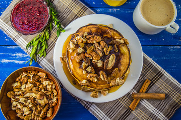 Pancakes with walnuts and maple syrup for breakfast. Close-up