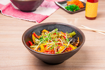 Traditional chinese wok dish vegetables in a sweet - sour sauce garnished with soybean sprouts in a round plate