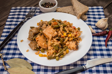 Paella with meat and vegetables. On a wooden background. Top view. Close-up