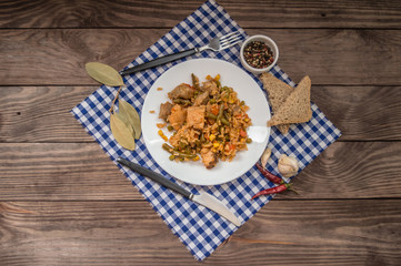 Paella with meat and vegetables. On a wooden background. Top view. Close-up