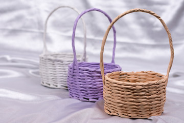 Fototapeta na wymiar Woven baskets for flower arrangements on the white satin
