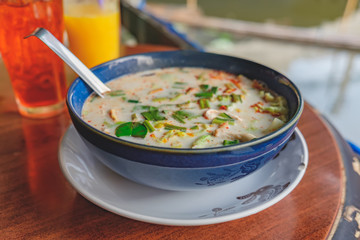 Thai cuisine, Tom Kha Kai closeup - chicken in coconut milk soup on the blurred cafe background.