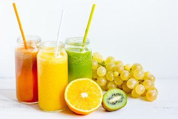 Fresh detox juices in glass bottles on white background