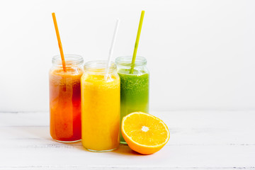 Fresh detox juices in glass bottles on white background