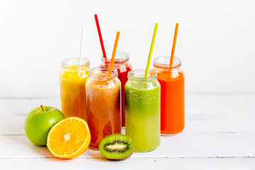 Fresh detox juices in glass bottles on white background