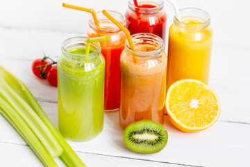 Fresh detox juices in glass bottles on white background
