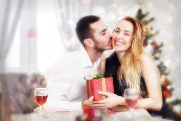 Man gives a woman a gift on Christmas Eve, bokeh effect