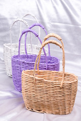 Fototapeta na wymiar Woven rustic paper basket on white satin