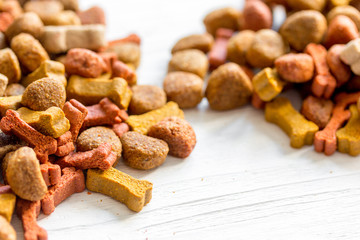 Fototapeta premium dry dog food in bulk on wooden background close up