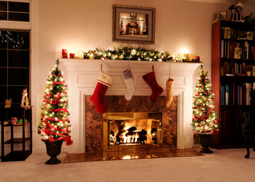 Living room decked out for the Christmas holidays with trees, stockings and a warm, welcoming fire