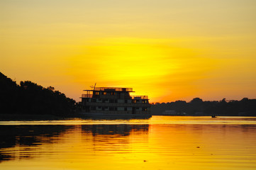 Obraz premium Cruise boat on the Amazon river at sunset.