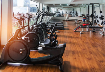 Reihen von stationären Fahrrad- und Gesundheitsübungsgeräten für das Bodybuilding im modernen Fitnessraum des Fitnessstudios