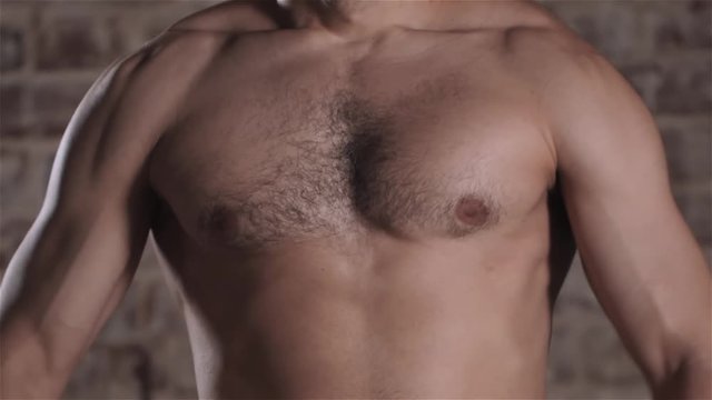 Handsome mature man with muscular topless body holding arms up. Fit businessman with biceps