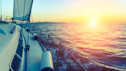 Sailing ship luxury yacht in the Sea during sunset.