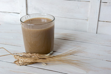 Traditional Drink from Balkan Peninsula Boza (fermented cereal beverage) and wheat over white wooden background