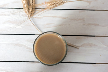 Traditional Drink from Balkan Peninsula Boza (fermented cereal beverage) and wheat over white wooden background
