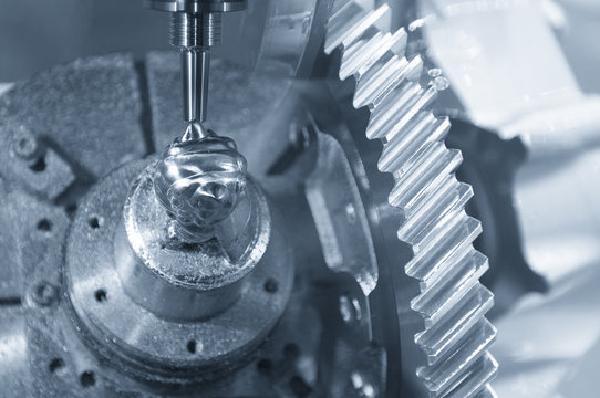 Abstract scene of the CNC milling machine while cutting the sample work piece and the pinion gear  in blue-silver tone