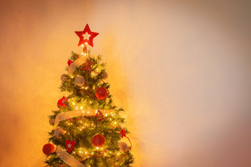 modern christmas tree with balls and golden strip decoration on warm background
