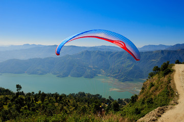 Pokhara, Nepal - November 3rd, 2016: View of a paraglider preparing to launch itself in the air.