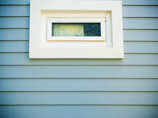 White window on blue wood wall