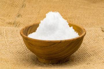 Closeup of white salt in a wooden bowl
