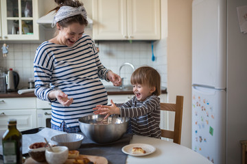 fun young pregnant mother   with son Toddler, make  dough for ba