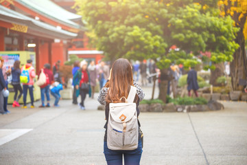 Back view of woman has backpack in Autumn season at Senso-ji temple in Asakusa District, a major...