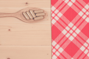 Herbal capsules on wooden spoon. herb for healthy